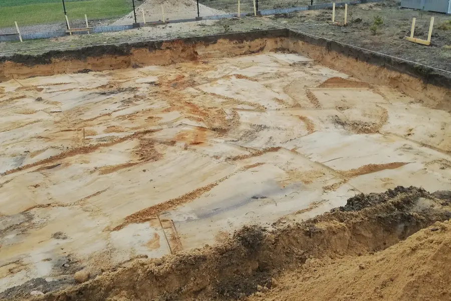 Duży wykop pod płytę fundamentową na ogrodzonej działce