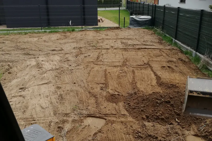 Wyrównany i wyprofilowany teren działki widziany z kabiny maszyny